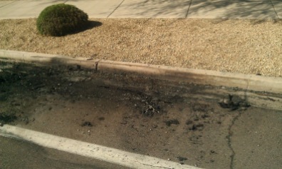 Ashes and road damage from the car fire.